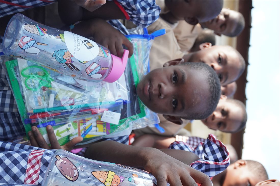 Enfant tenant un kit scolaire offert par la Fondation O'Takkos